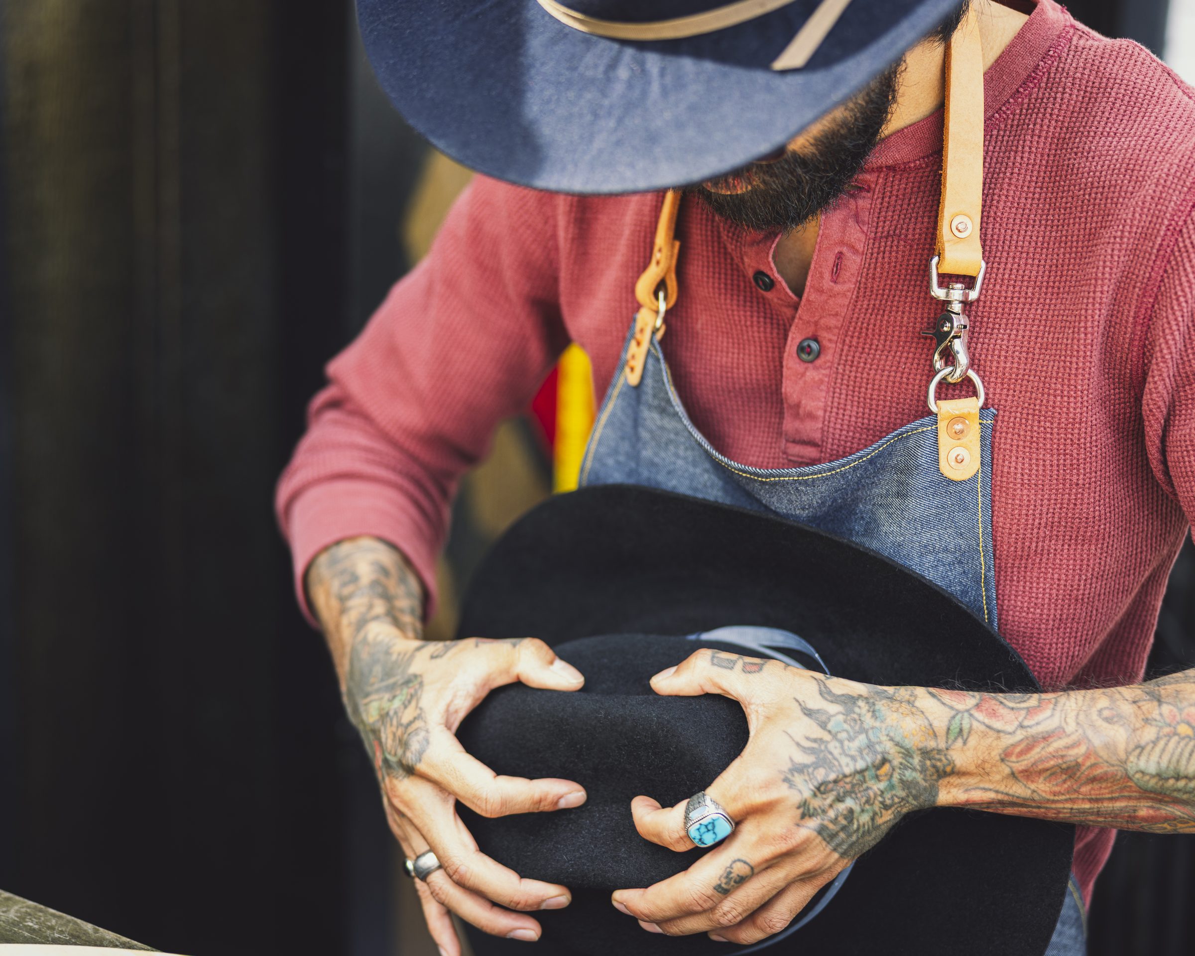 Hands shaping a black felt hat crown